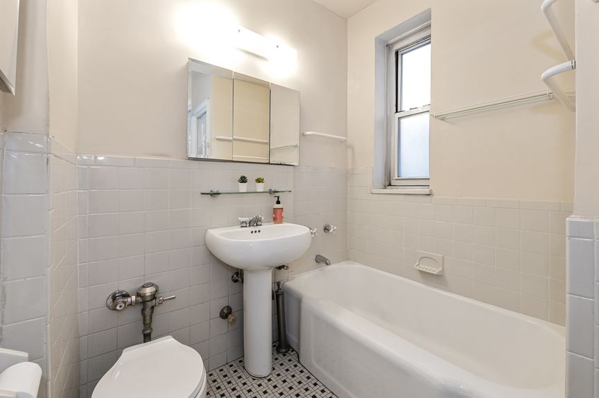 Bathroom with bathtub, pedestal sink, and toilet