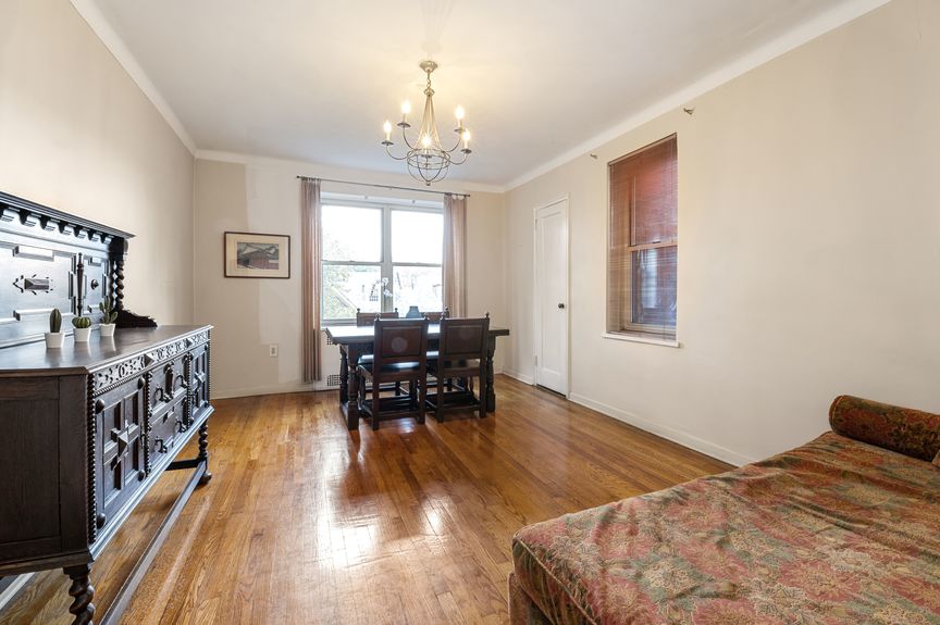 Bedroom with a couch, large table, and chandelier