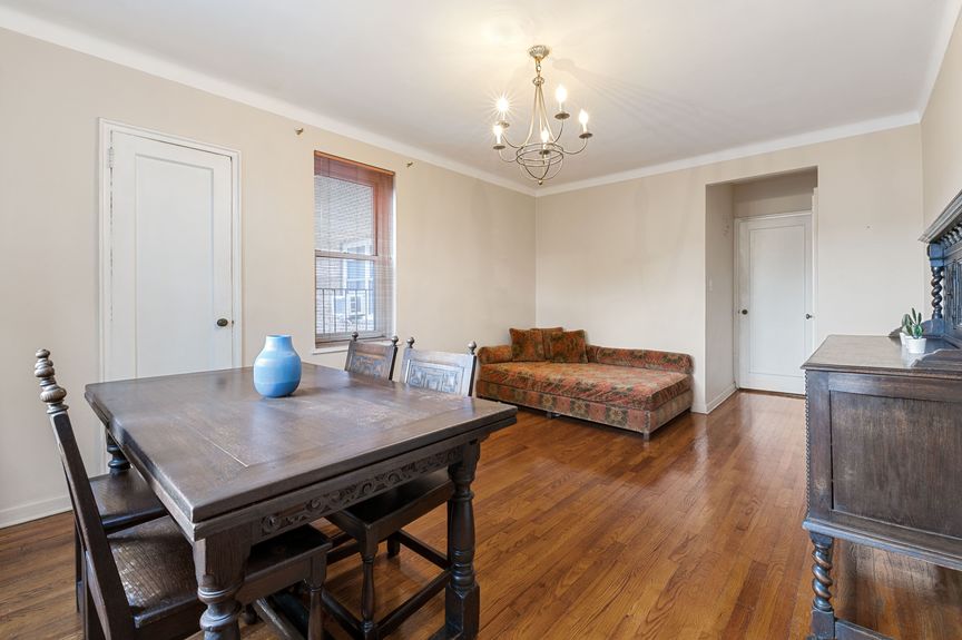 Bedroom with a couch, large table, and chandelier