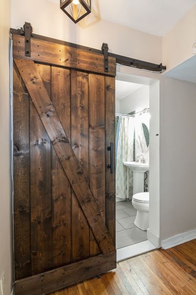 Wooden sliding barn door to the bathroom