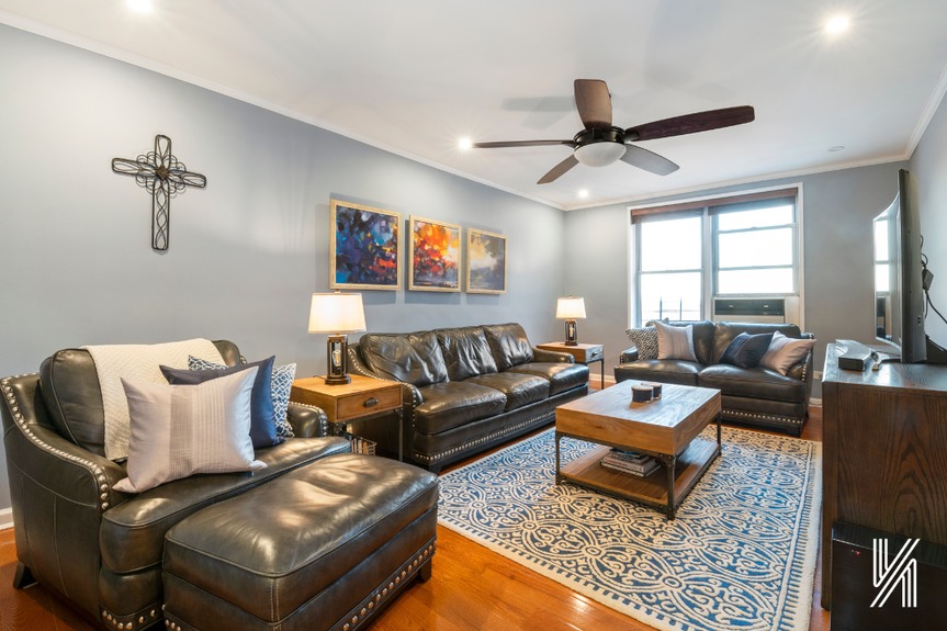 Living room with city views, three big couches, and a center table