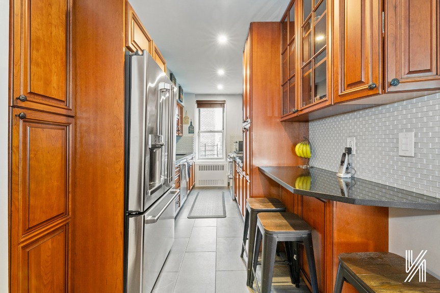 Kitchen with modern cherrywood cabinetry, floor-to-ceiling pantry with pull-out drawers and shelves, and a pull-out spice rack