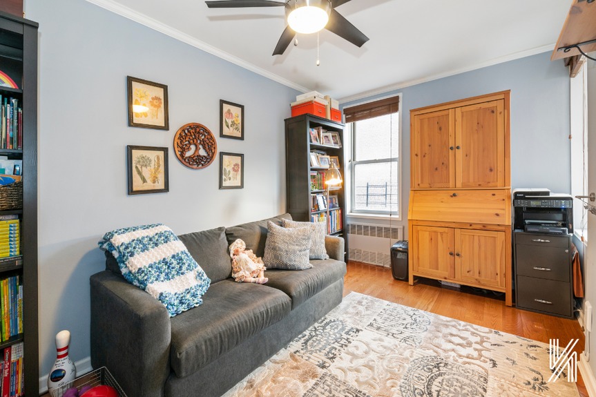 First bedroom with a large couch, Custom Elfa closets, and two bookshelves