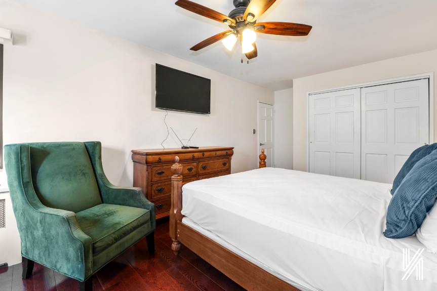Another angle of the bedroom that includes a good-looking green couch