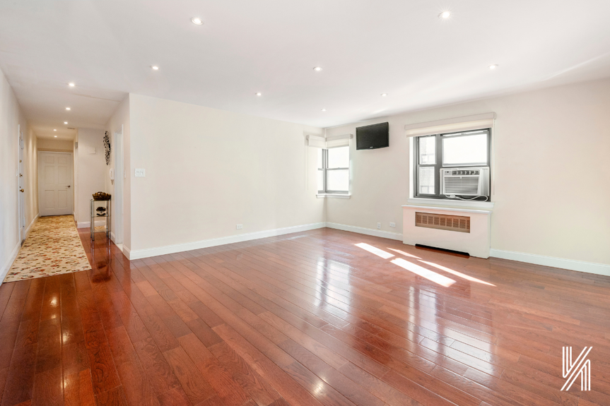 The empty living room shows the elegant, soundproof cherry wood flooring.