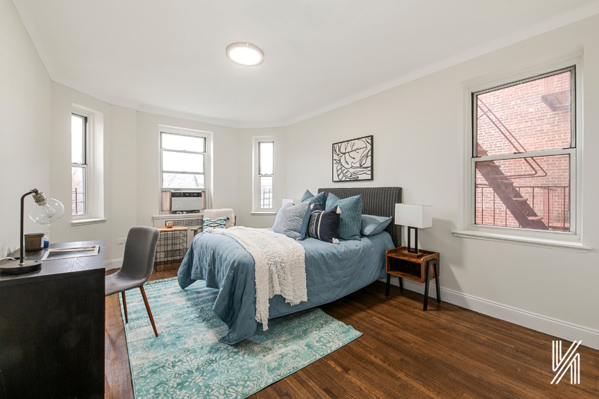 Bedroom with bedside lamp, office table and 3 windows