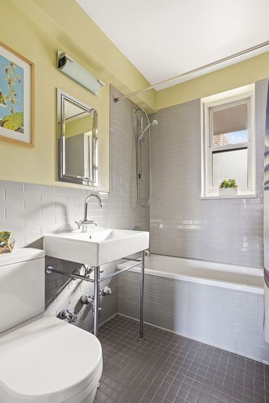 Bathroom with a squared mirror, bathtub, and toilet.