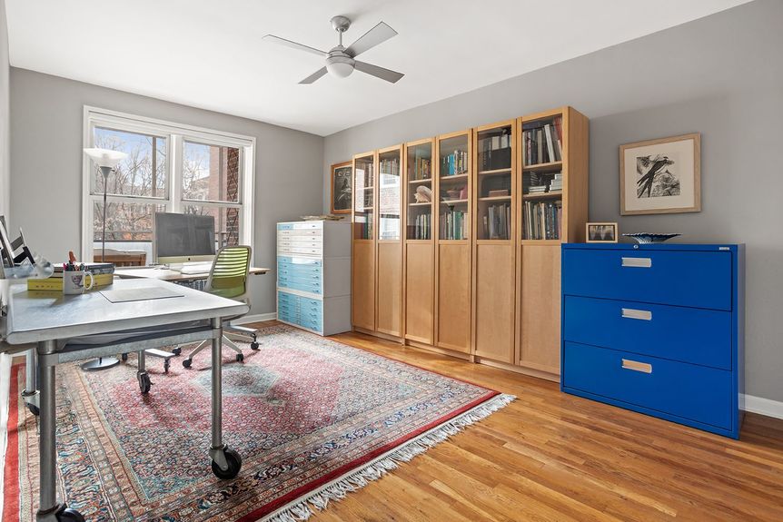 A spacious office area with bookshelves and hardwood floors.