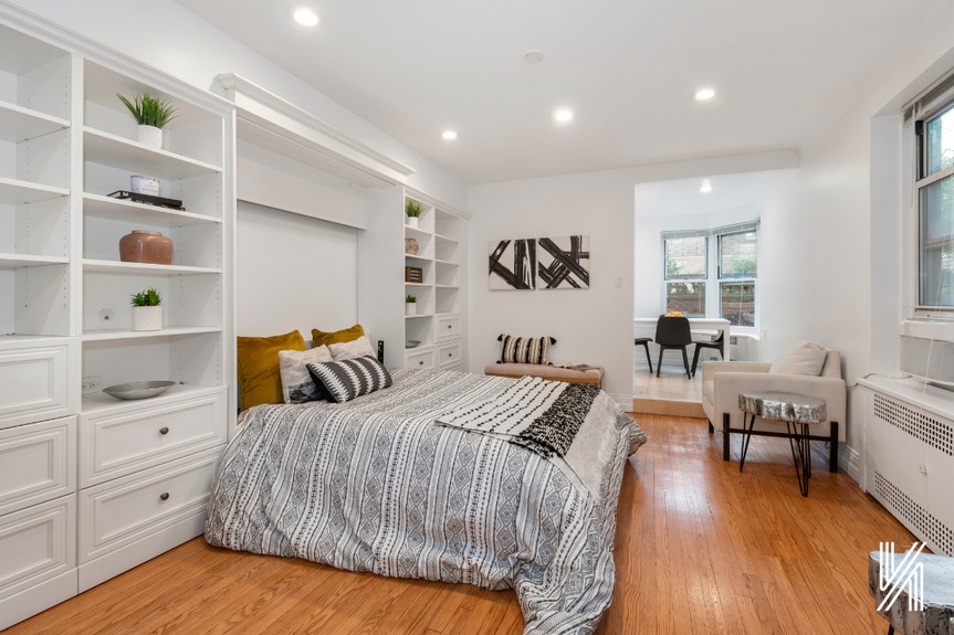 Room with bed and large window and shelves