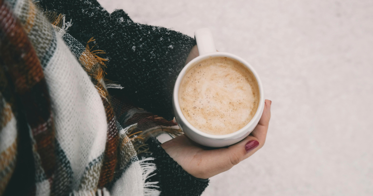 a woman holding a coffee during winter