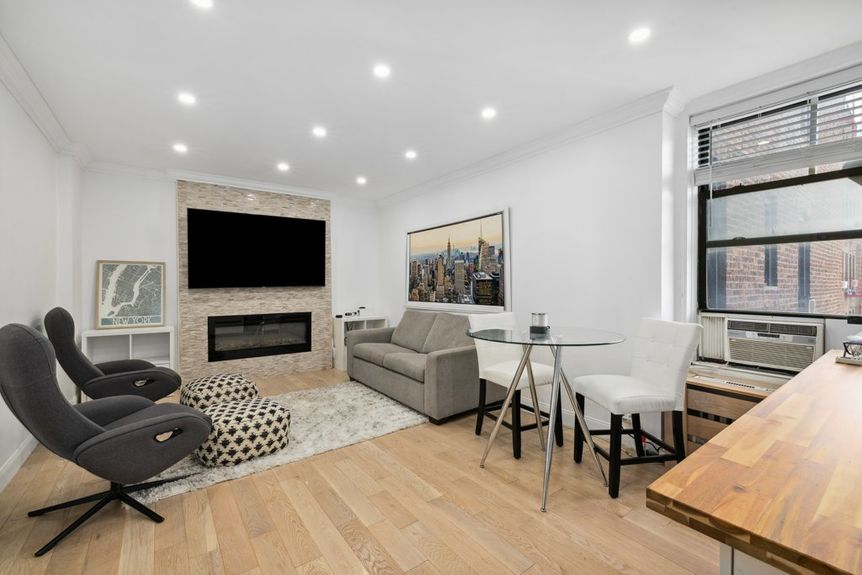 Living Room with beautiful hardwood floors, a couch, and two office chairs