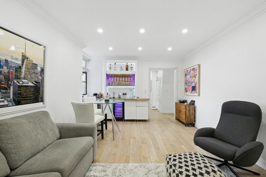 Living Room with beautiful hardwood floors, a couch, two office chairs, and a dining table