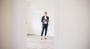 Woman in empty apartment with tablet