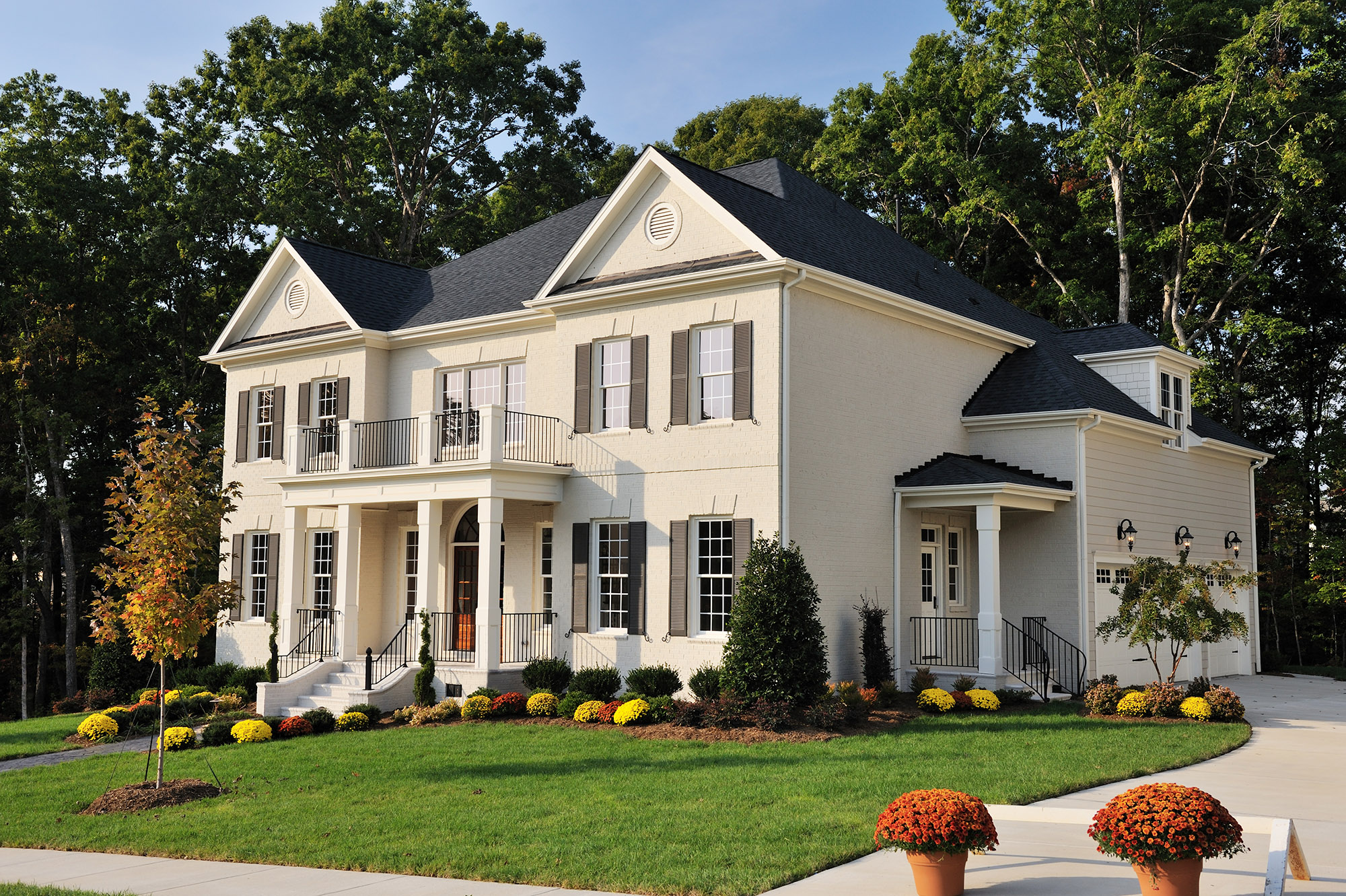 Picture of a ivory-white house with grass in the front yard