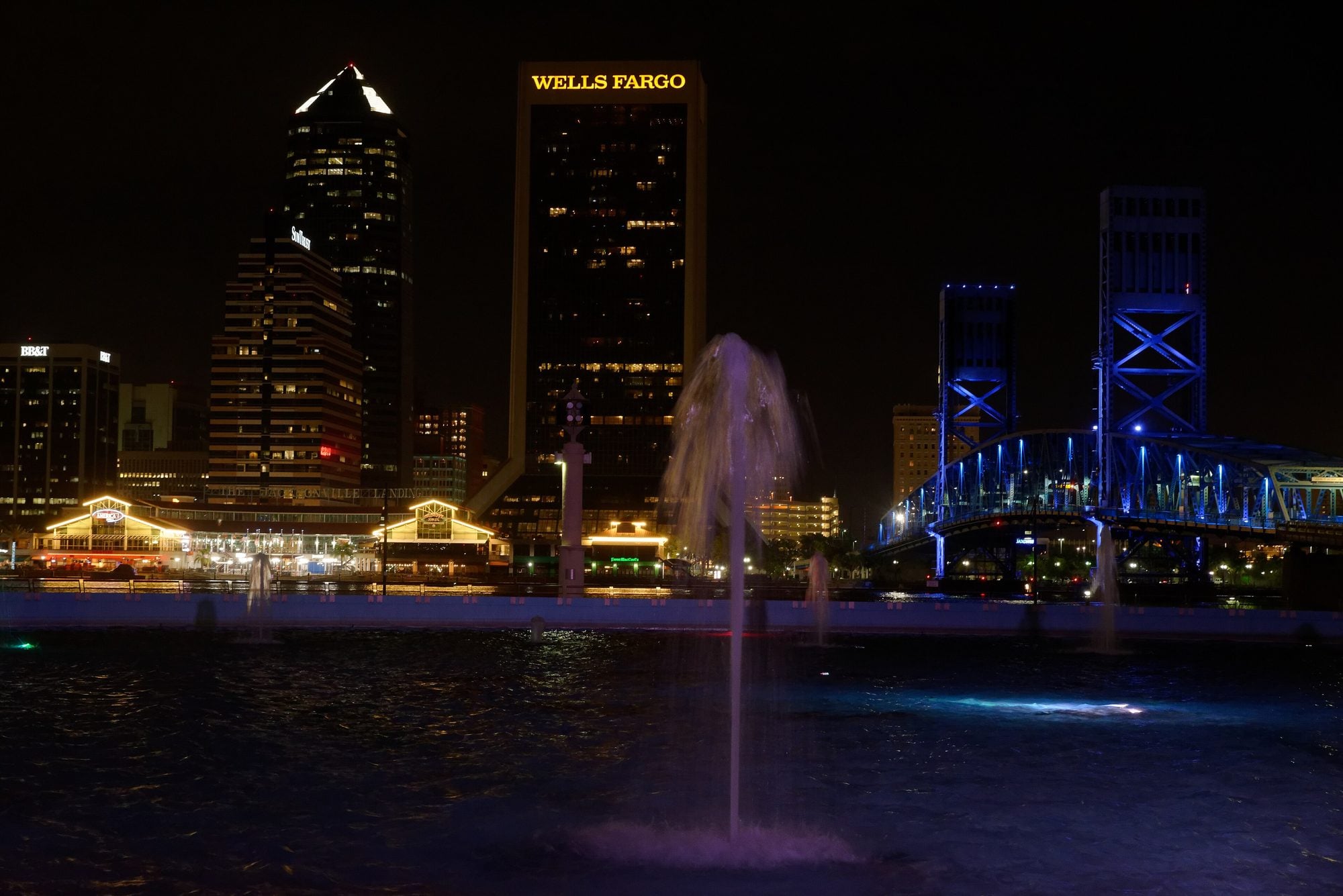Friendship Fountain lit at night beside the St. Johns River and downtown Jacksonville skyline