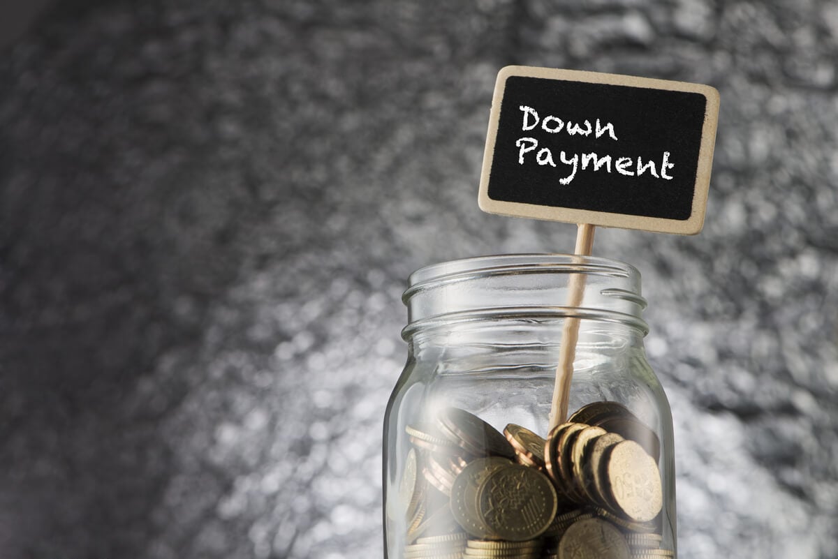 Down payment sign inside a jar of coins