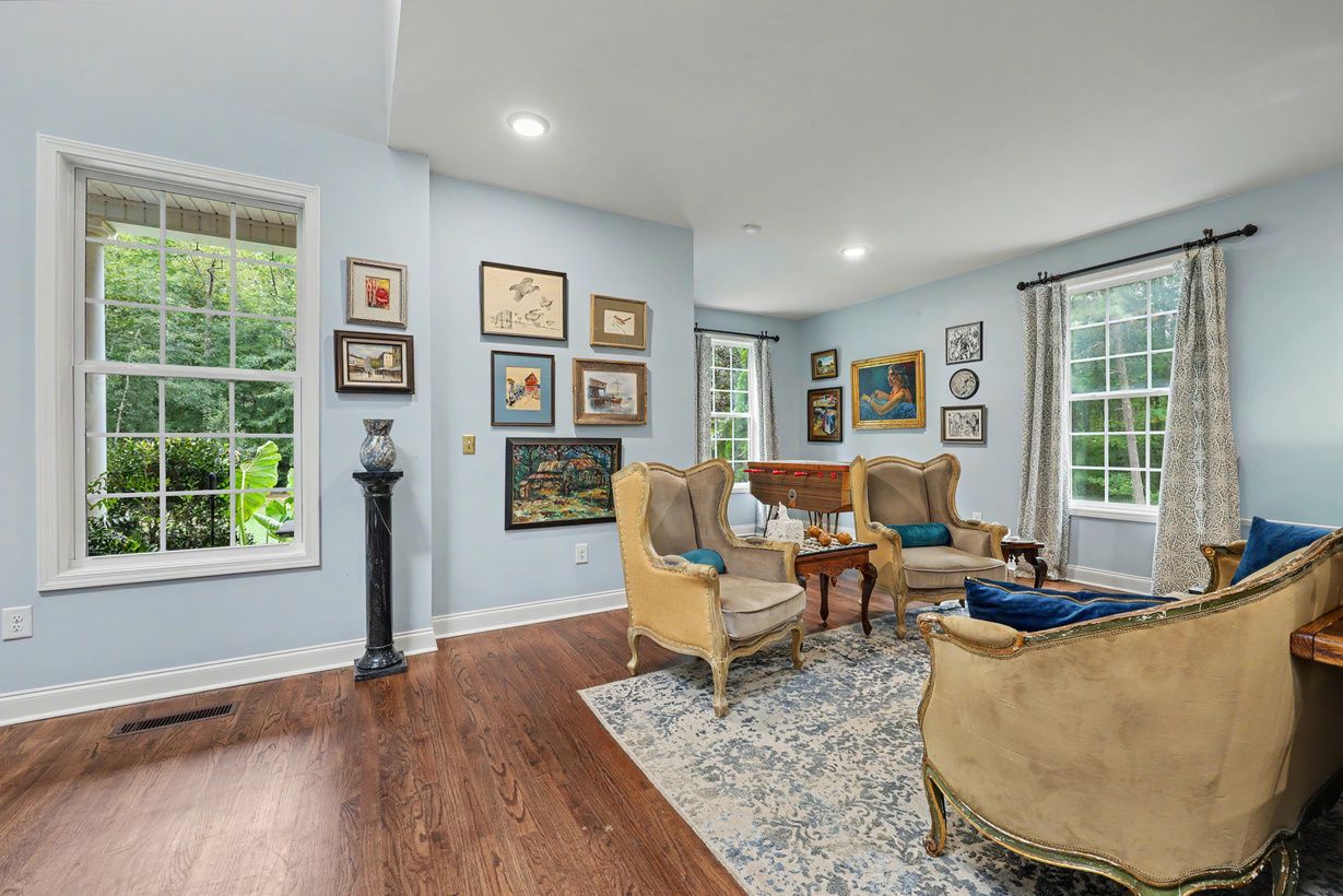 Sitting room with gilded armchairs and a salon-style gallery wall