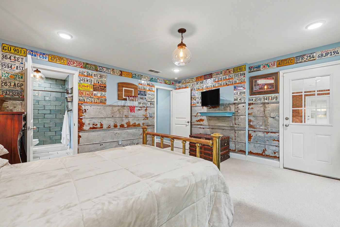 Bedroom with walls lined in vintage license plates