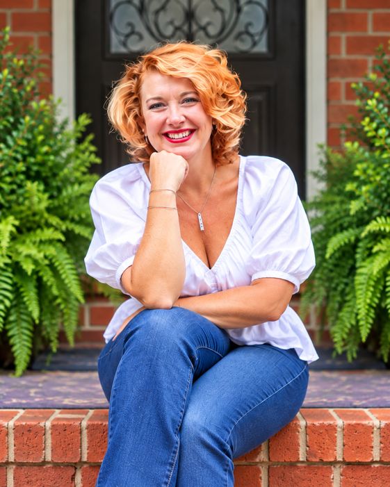 Portrait of artist Virginia Cartey seated on the brick front steps