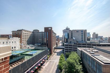Elevated downtown view facing Monroe Center with hotel towers, PNC Bank building, parking structure, and tree‑lined street