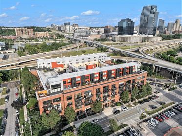 High drone photo of Union Square Condos with downtown Grand Rapids towers and intersecting highways in the background.