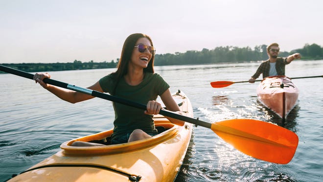 People kayaking on the calm waters of Lake Travis surrounded by scenic Texas Hill Country views.