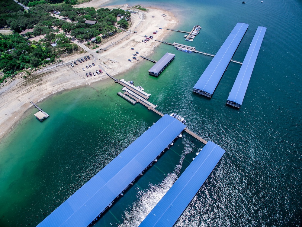 Aerial view of Lake Travis at full water levels with floating boat houses and waterfront homes