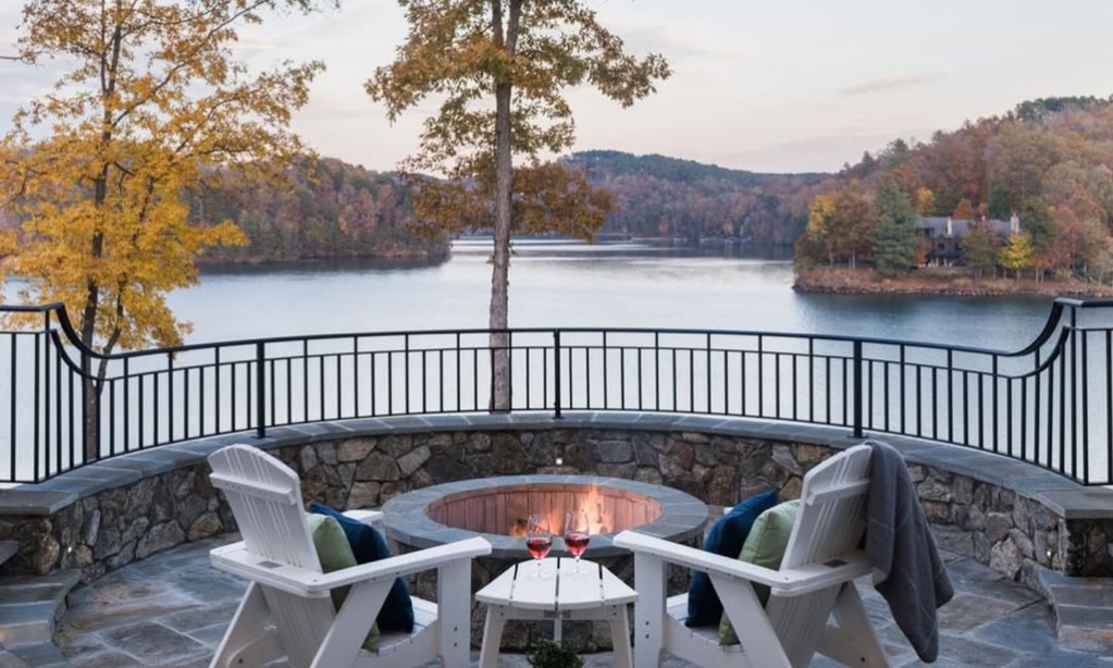 Family and friends gathered outdoors at a luxury lakefront home in Central Texas during sunset overlooking the water.